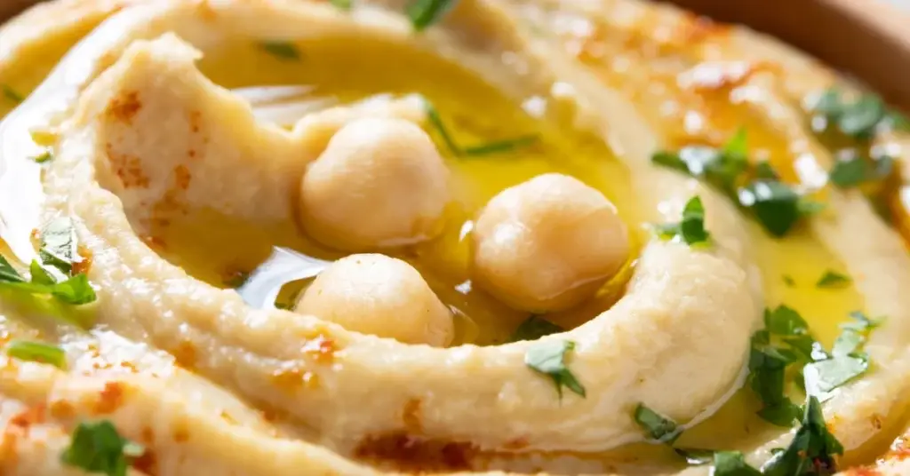 Creamy hummus topped with chickpeas, fresh herbs and a drizzle of golden rapeseed oil.