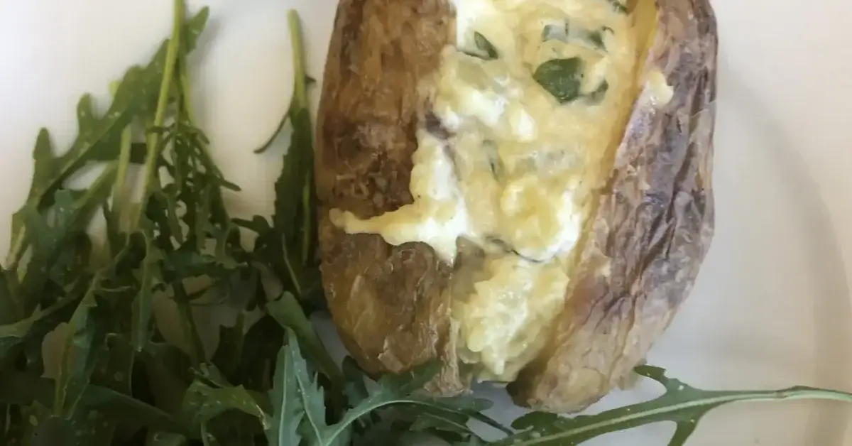 Jacket potato with creamy filling served with fresh rocket salad