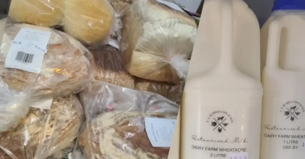 Fresh bread, potatoes and local milk displayed together inside Yare Valley Farm Shop.