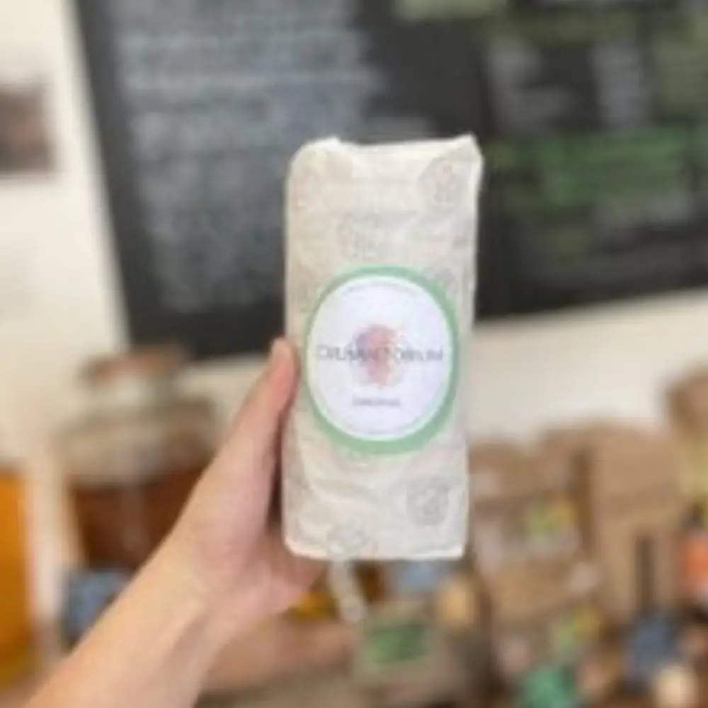 Packaged Dalston’s chocolate product held inside Yare Valley Farm Shop with the shop chalkboard in the background.